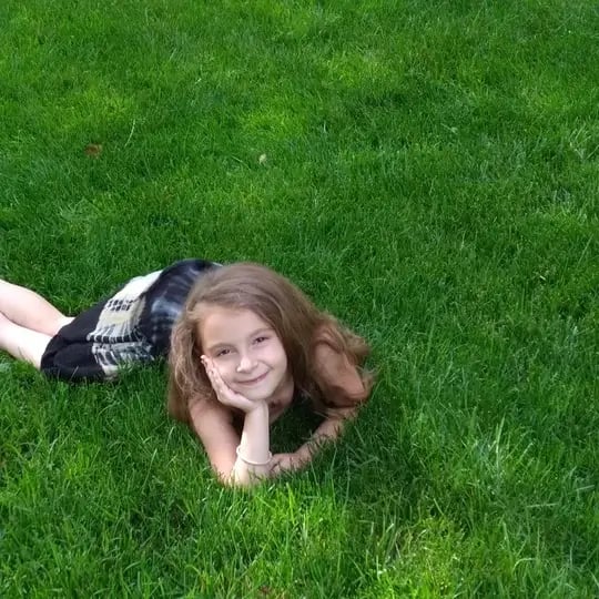 girl laying in green grass